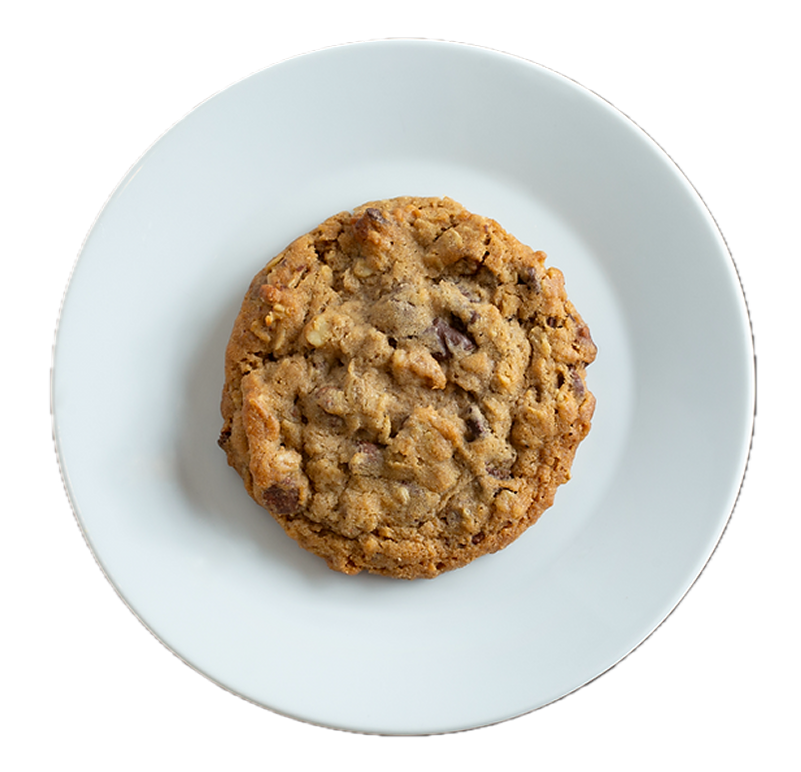 Golden brown chocolate chip cookie with nuts on a white ceramic plate against white background