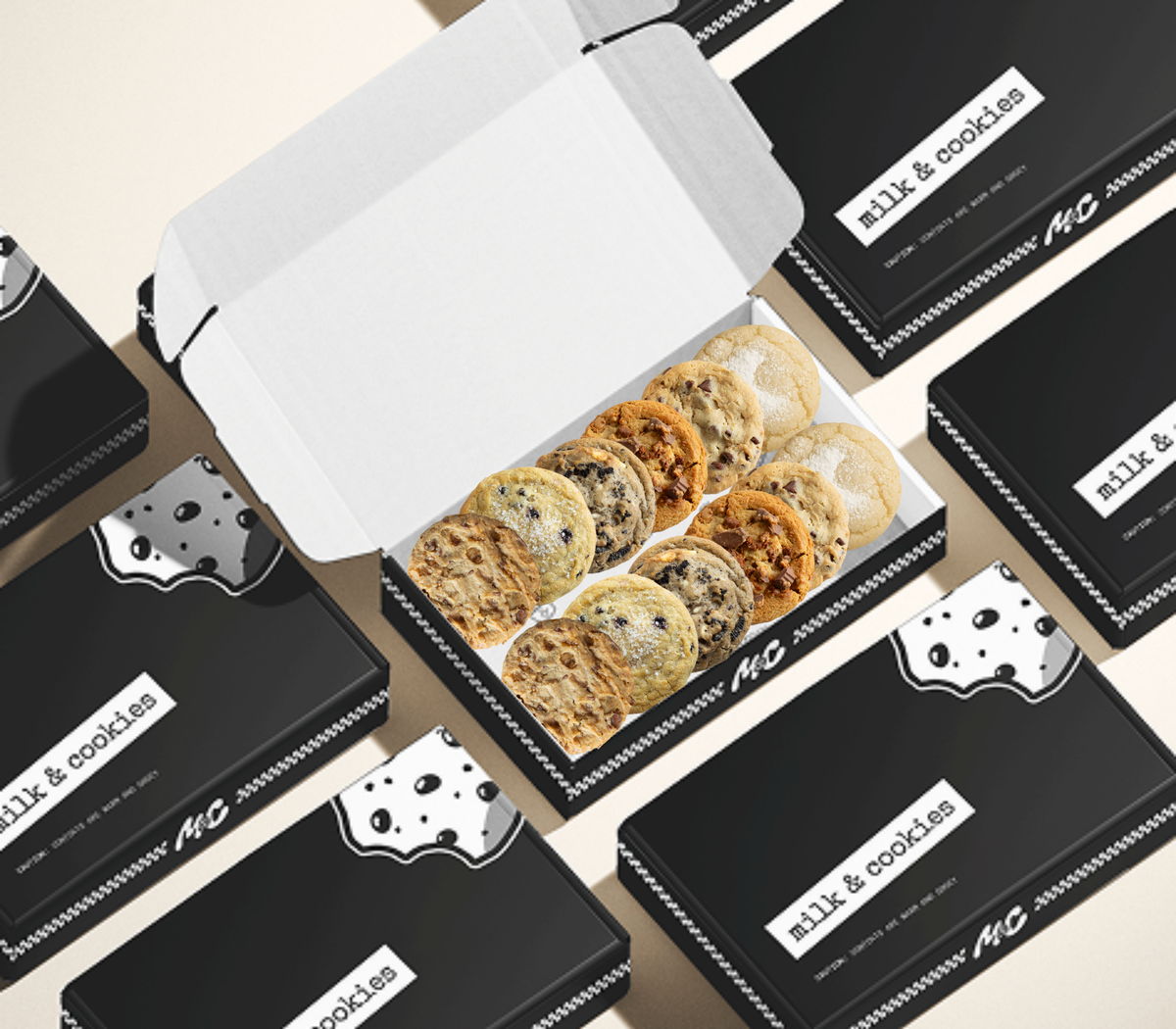 Box of assorted cookies with "Milk & Cookies" branded packaging scattered around on beige background