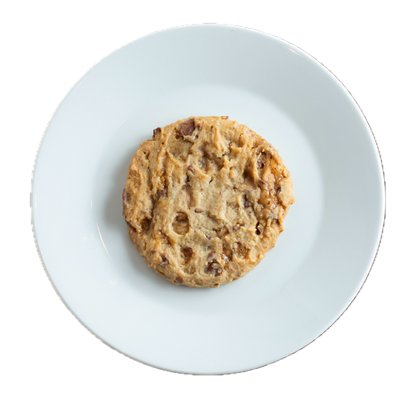 Golden brown chocolate chip cookie on a light blue ceramic plate against white background